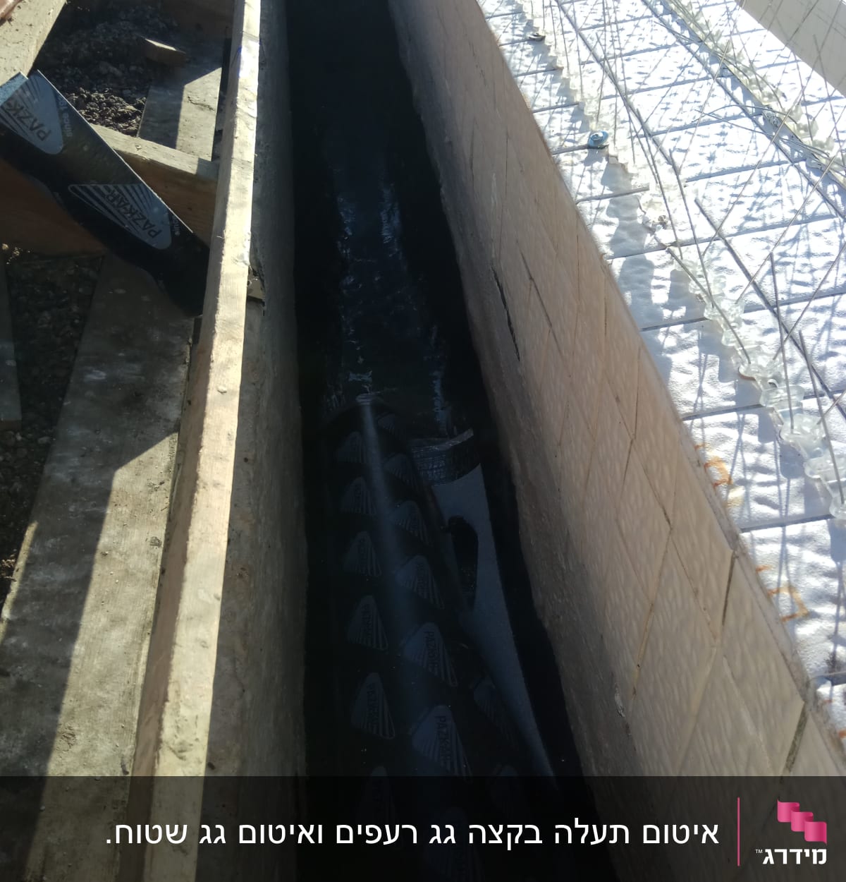 חומר איטום שחור מונח בתעלה בין קירות